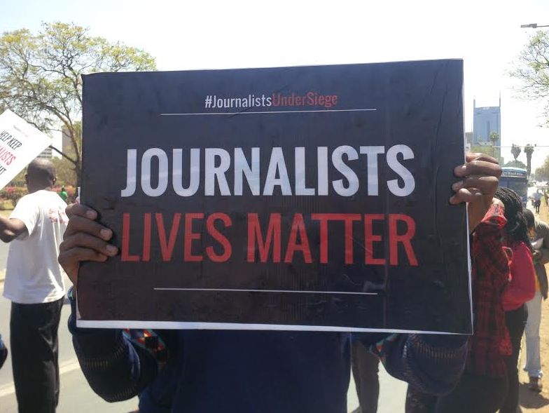 A protester holds a placard with the words: "Journalists lives matter"